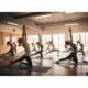 Group of diverse individuals practicing Bikram yoga in a bright, warm studio, showcasing flexibility and community spirit